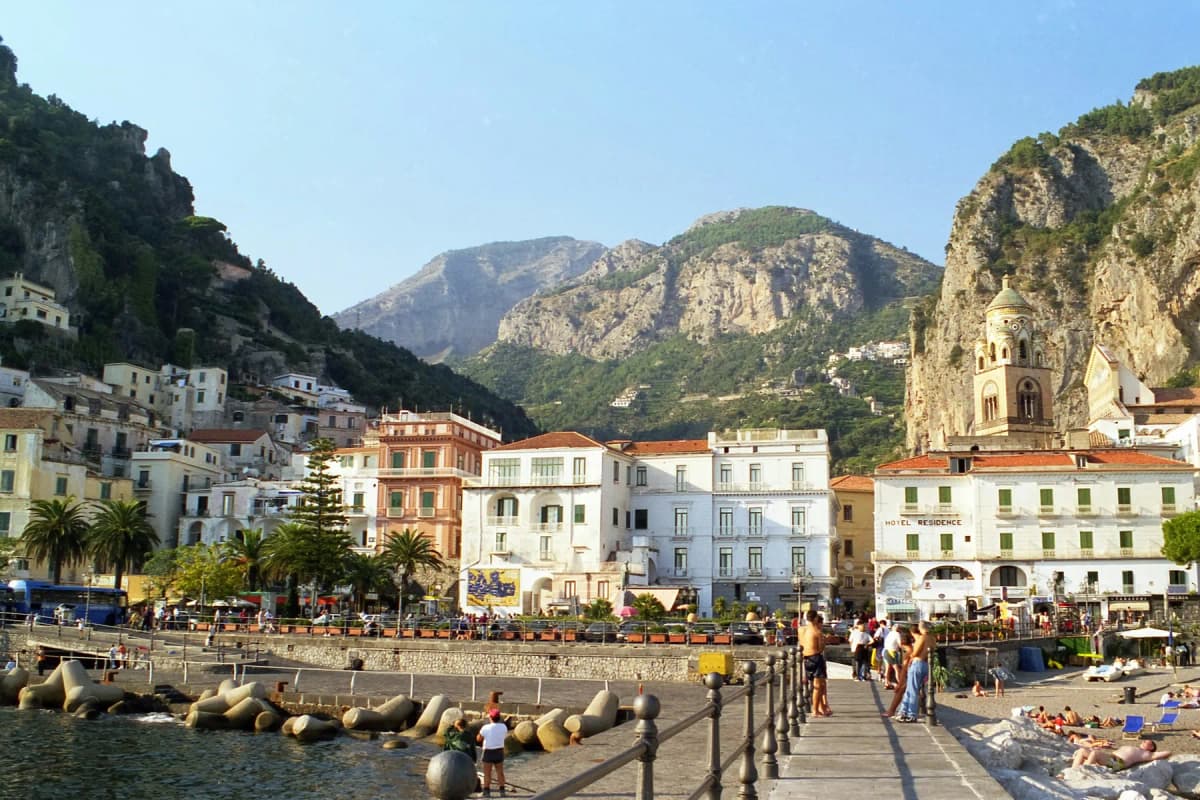 Amalfi Coast itinerary day 1: Amalfi town and its harbour seen from the end of the pier, with mountains behind