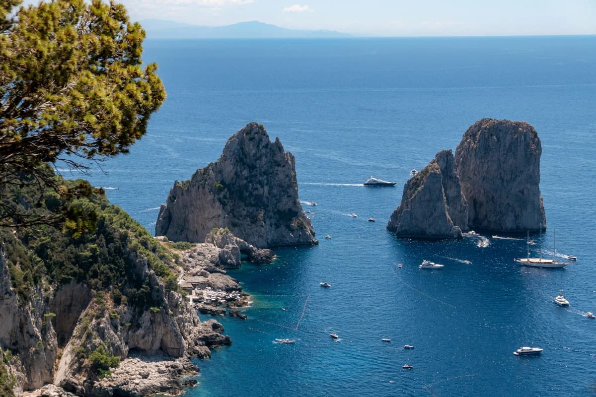 The Faraglioni rock stacks off Capri with small boats on deep blue water