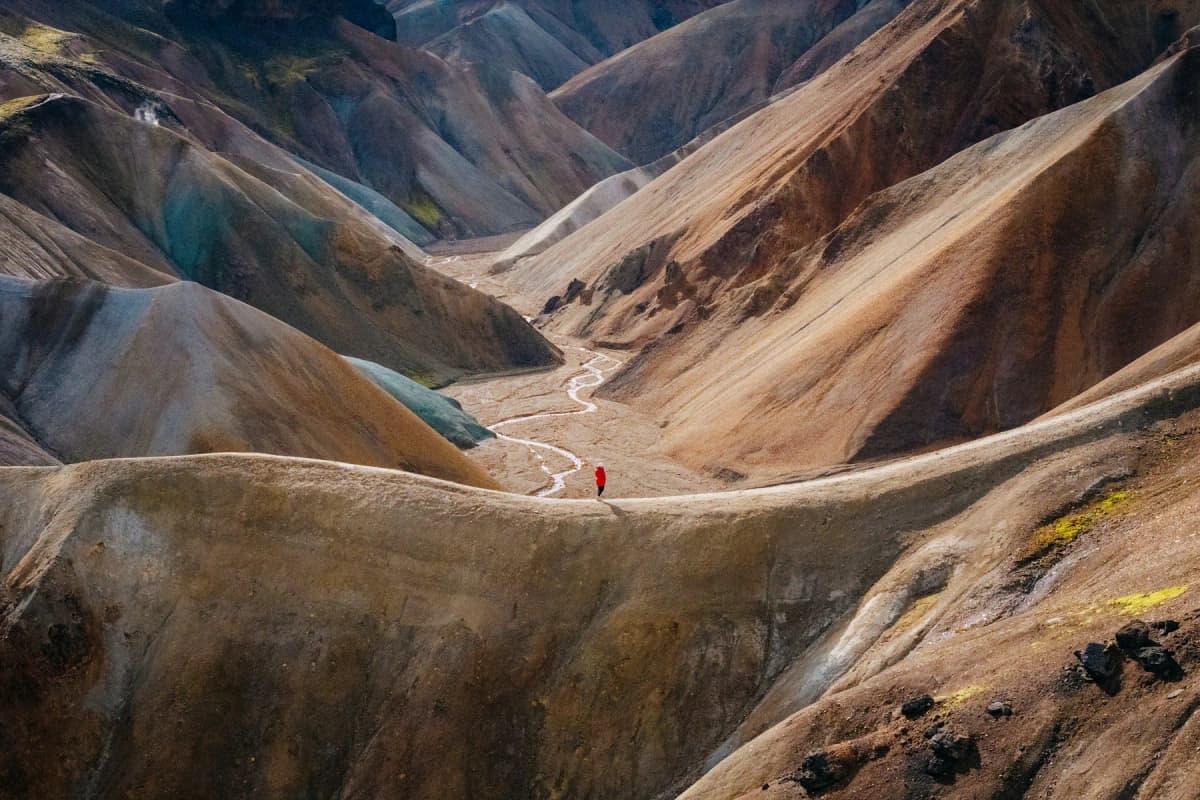 Best places to visit in Iceland: a hiker on a trail through the multicoloured rhyolite mountains of Landmannalaugar