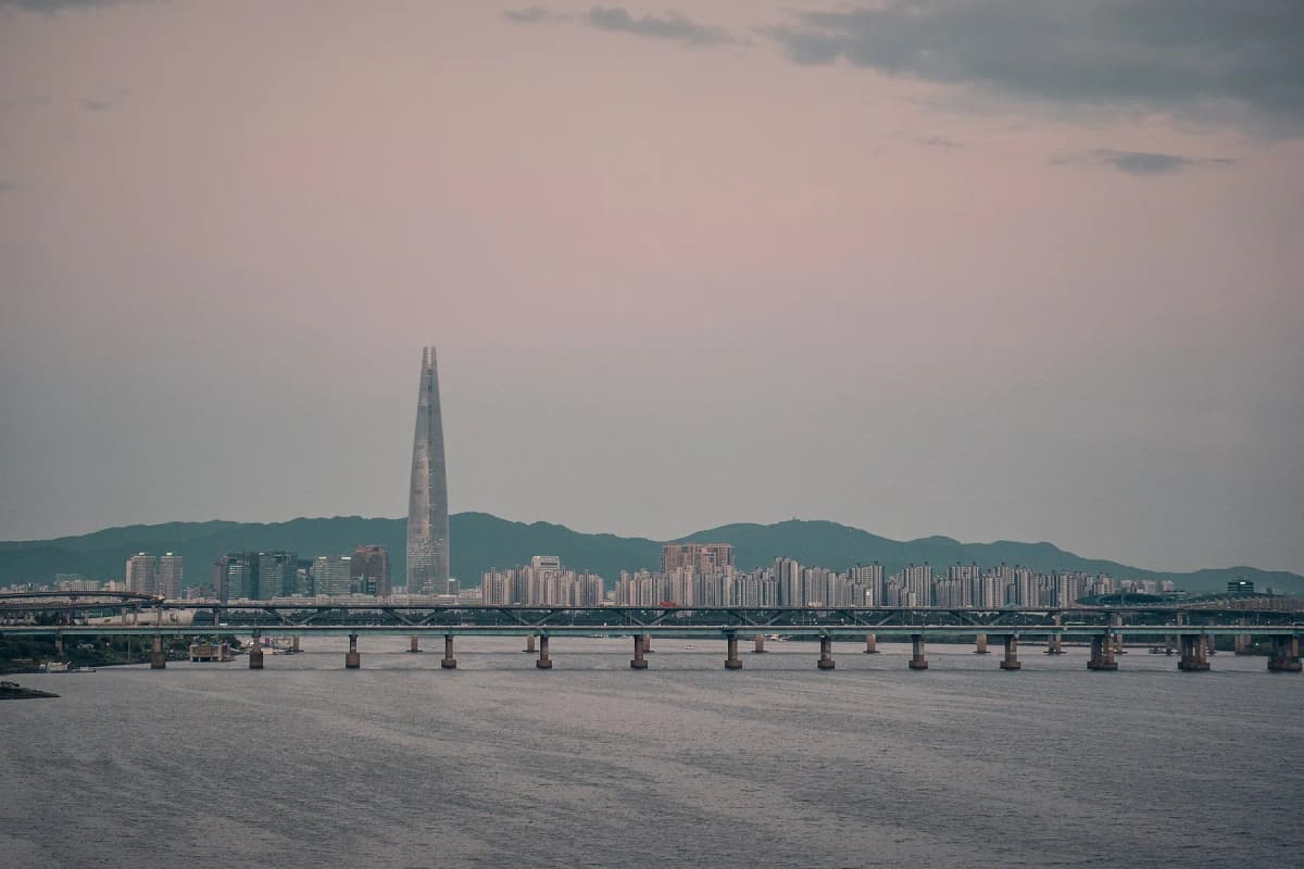 The Han River in Seoul with a long bridge and the Lotte World Tower on the skyline