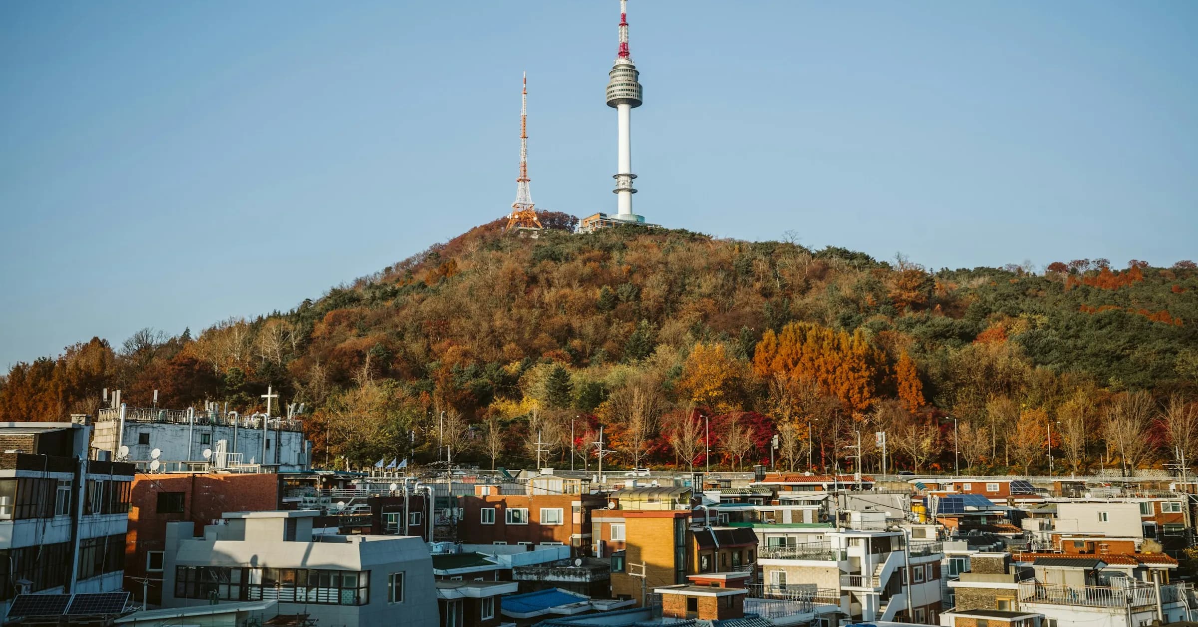 N Seoul Tower on top of Namsan, with the hillside in autumn colours above the rooftops of central Seoul