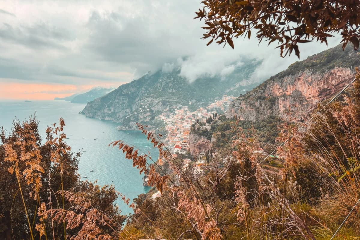 The Amalfi Coast in autumn seen through golden foliage, with mist over the hills