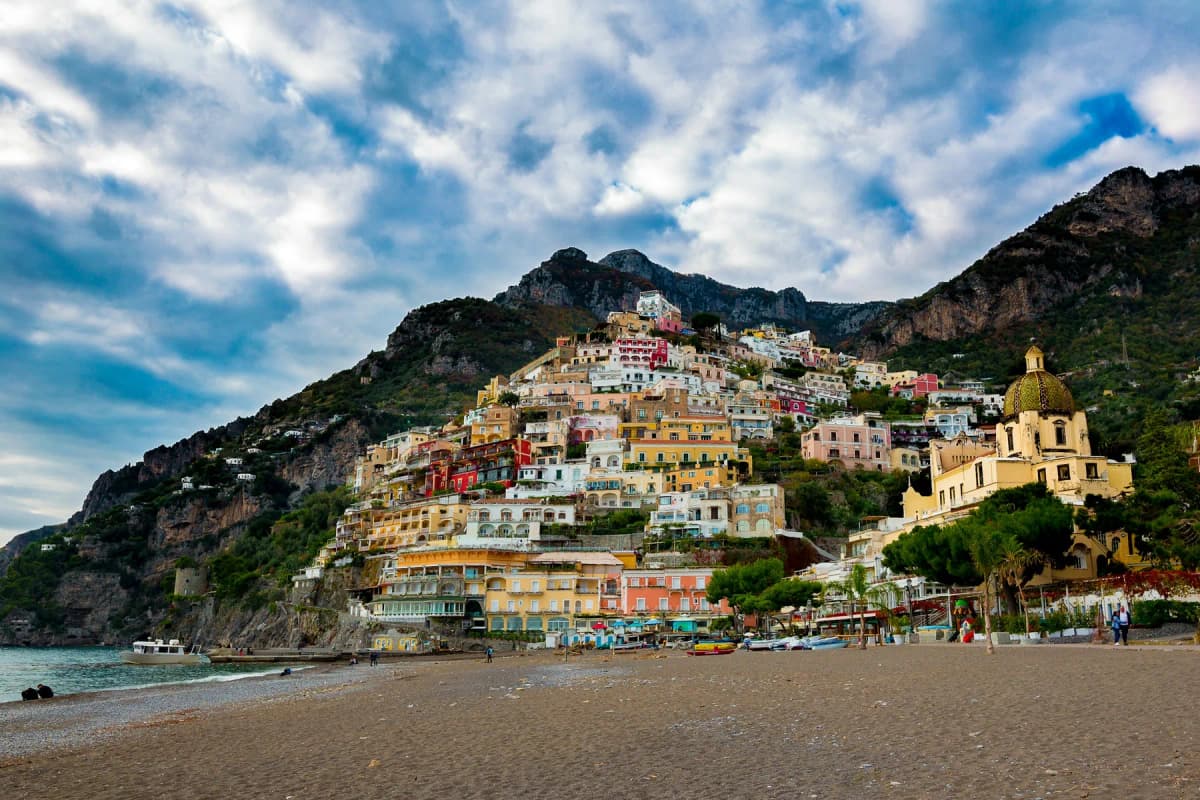 Positano seen from a quiet beach under a cloudy sky outside the summer season