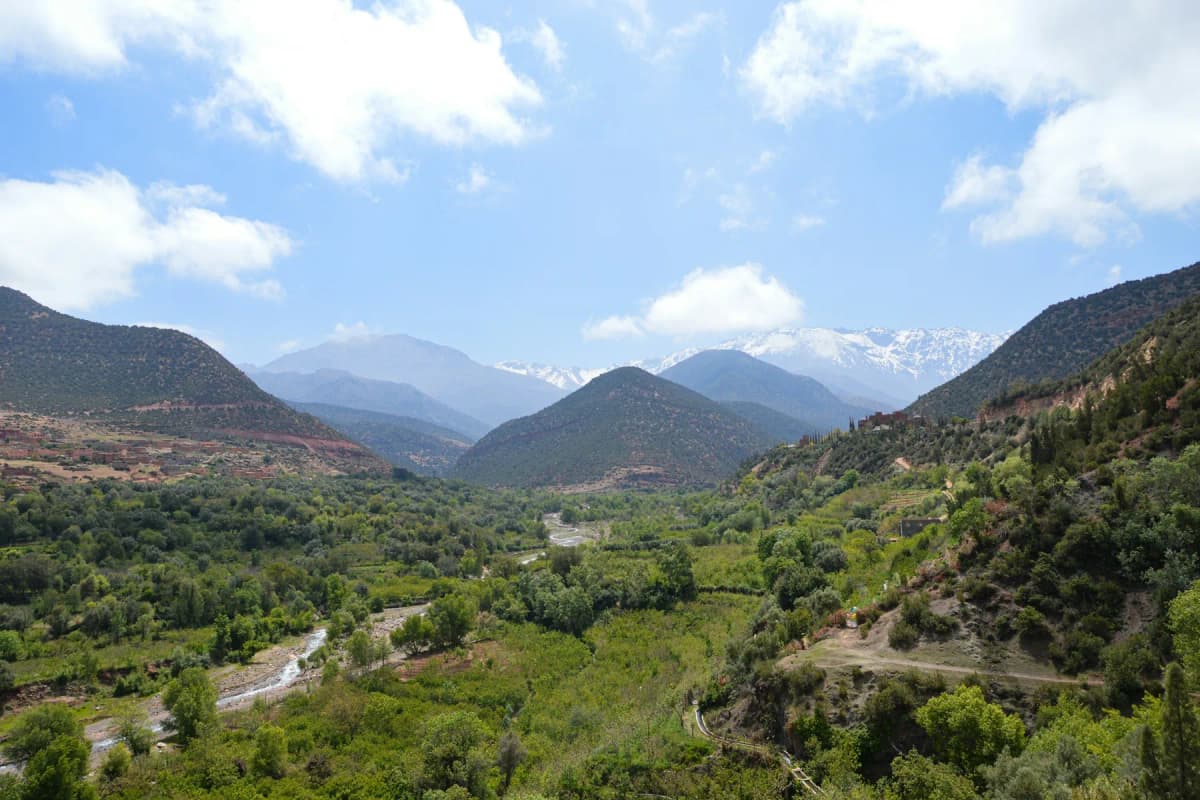 Best time to visit Morocco in spring: a green valley at Asni with the snowy peaks of the High Atlas behind
