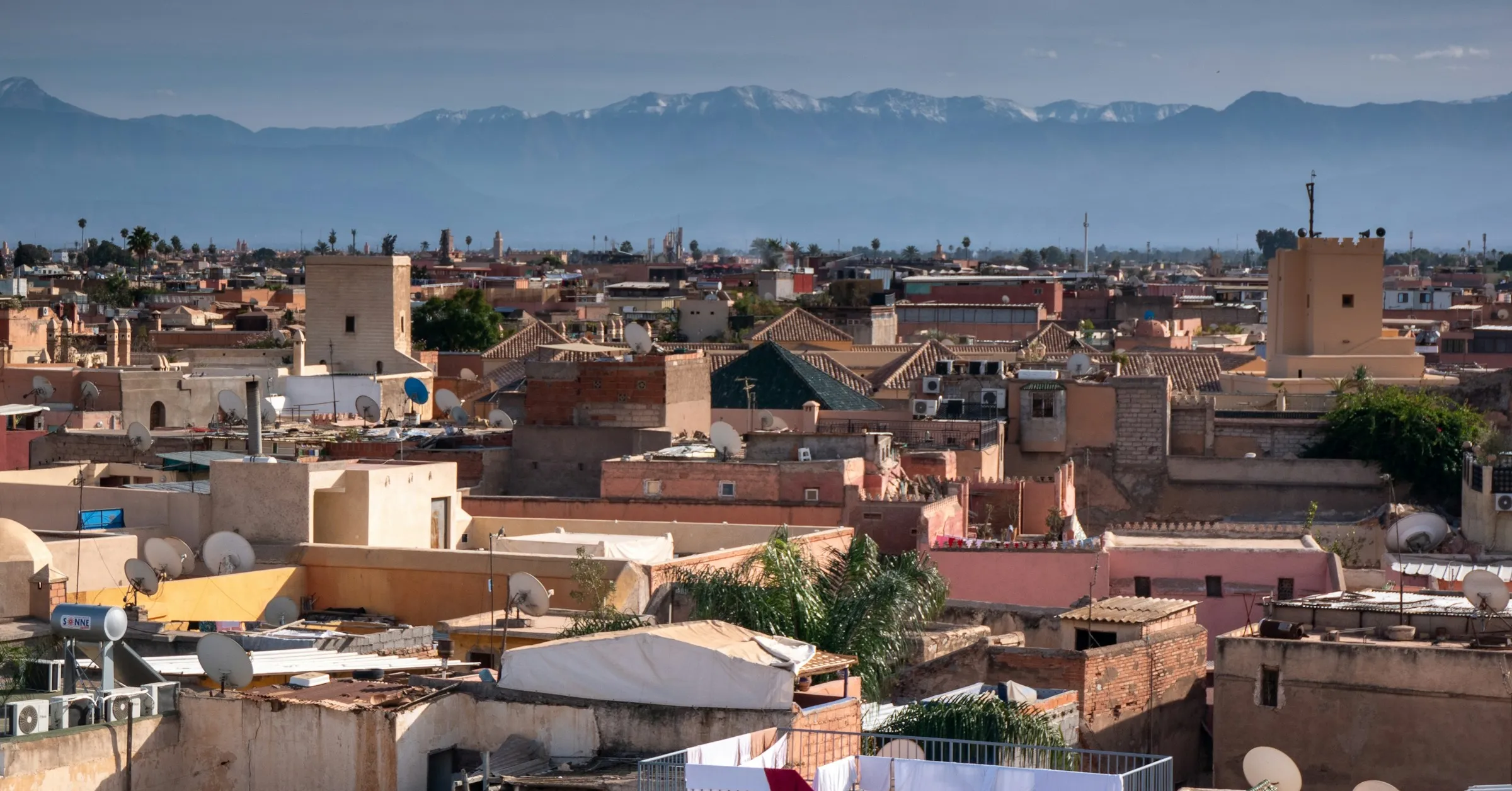 Best time to visit Morocco: the rooftops of the Marrakech medina with the snow-capped Atlas mountains behind