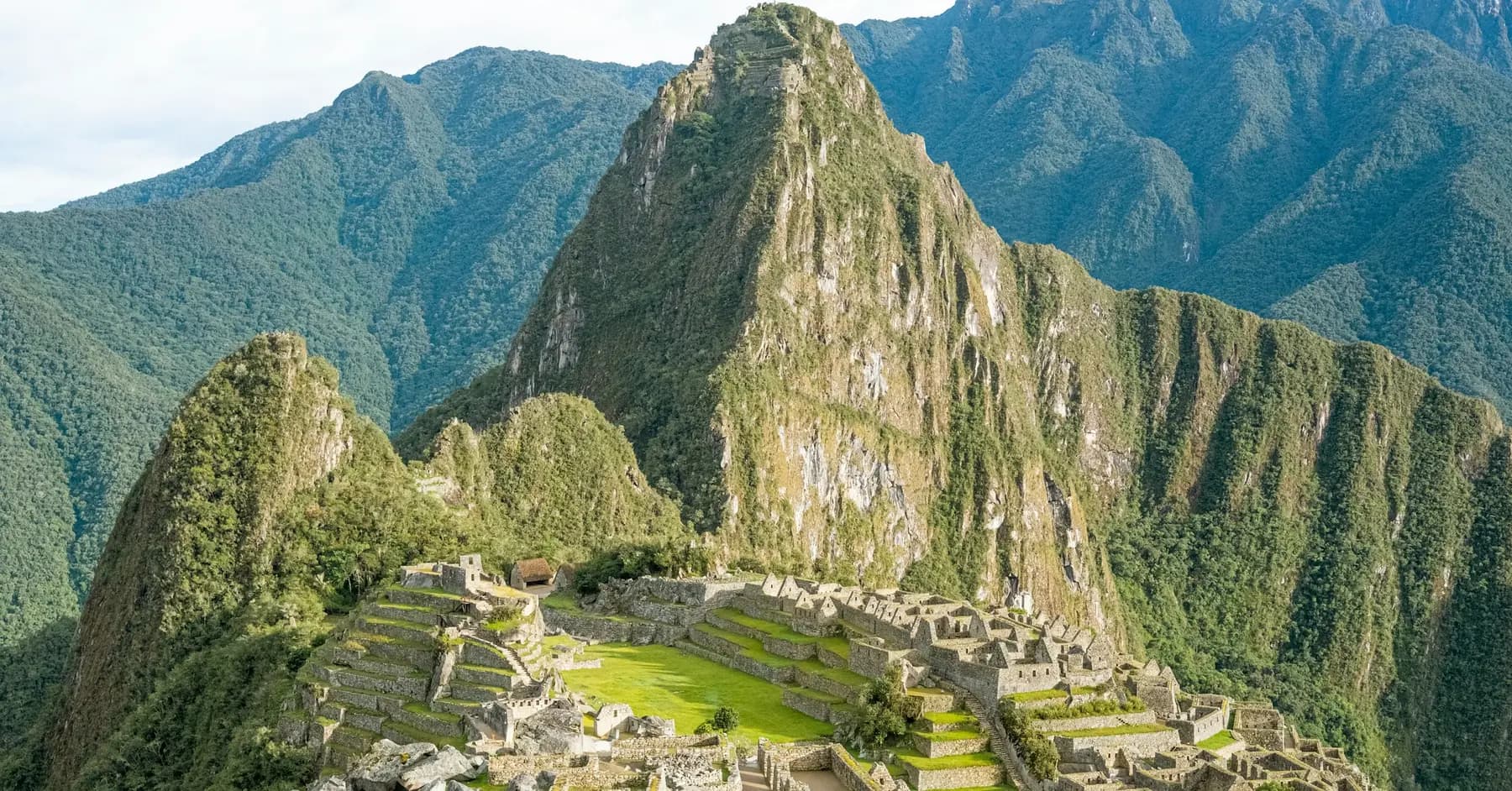 Best time to visit Peru: the terraces of Machu Picchu under green peaks on a clear day