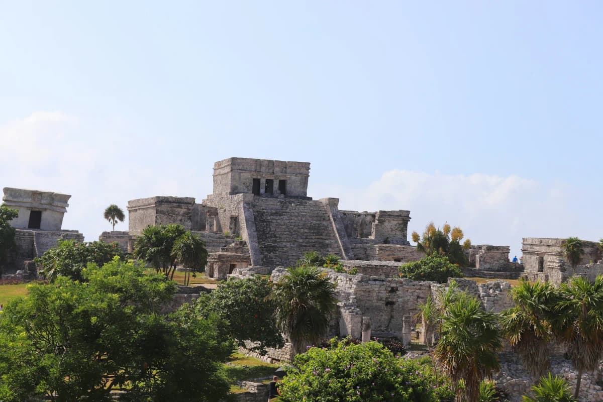 The El Castillo ruins on the cliff above the sea at Tulum, under a blue sky