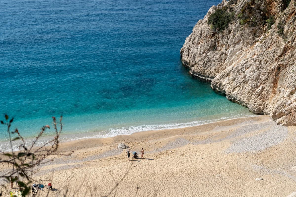 A turquoise cove on Turkey's Mediterranean coast, below a rocky cliff