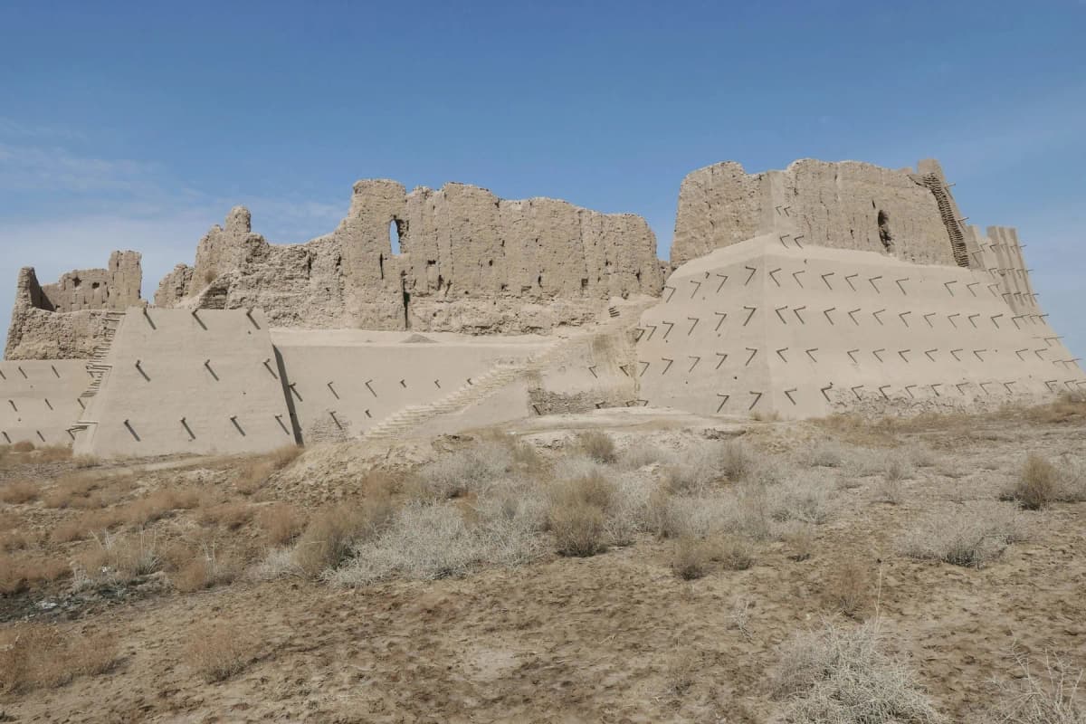 The eroded mud-brick walls of an ancient Elliq Qala fortress in the desert near Khiva