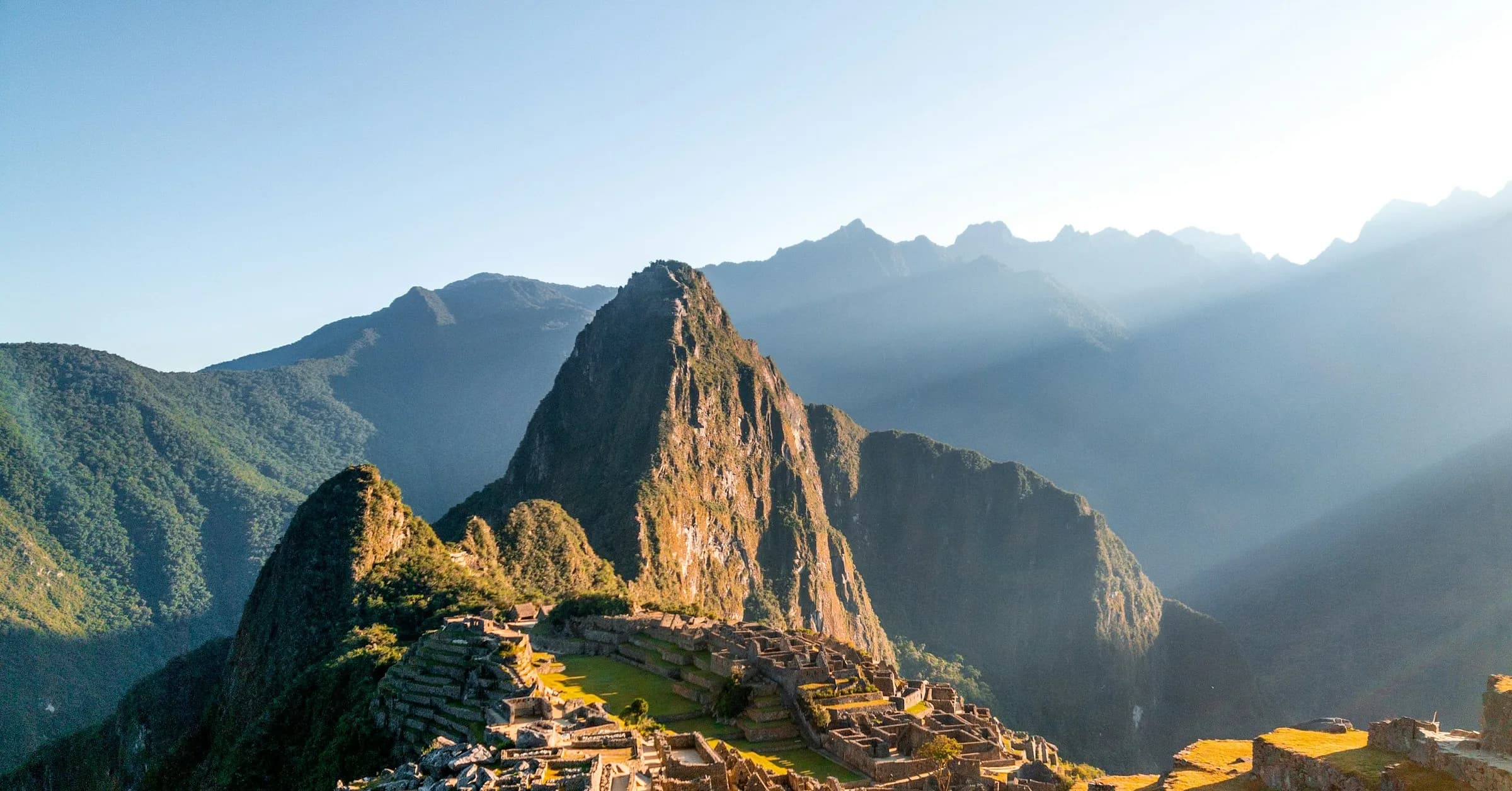 Day trips from Cusco: the ruins of Machu Picchu lit by the morning sun, with Huayna Picchu behind