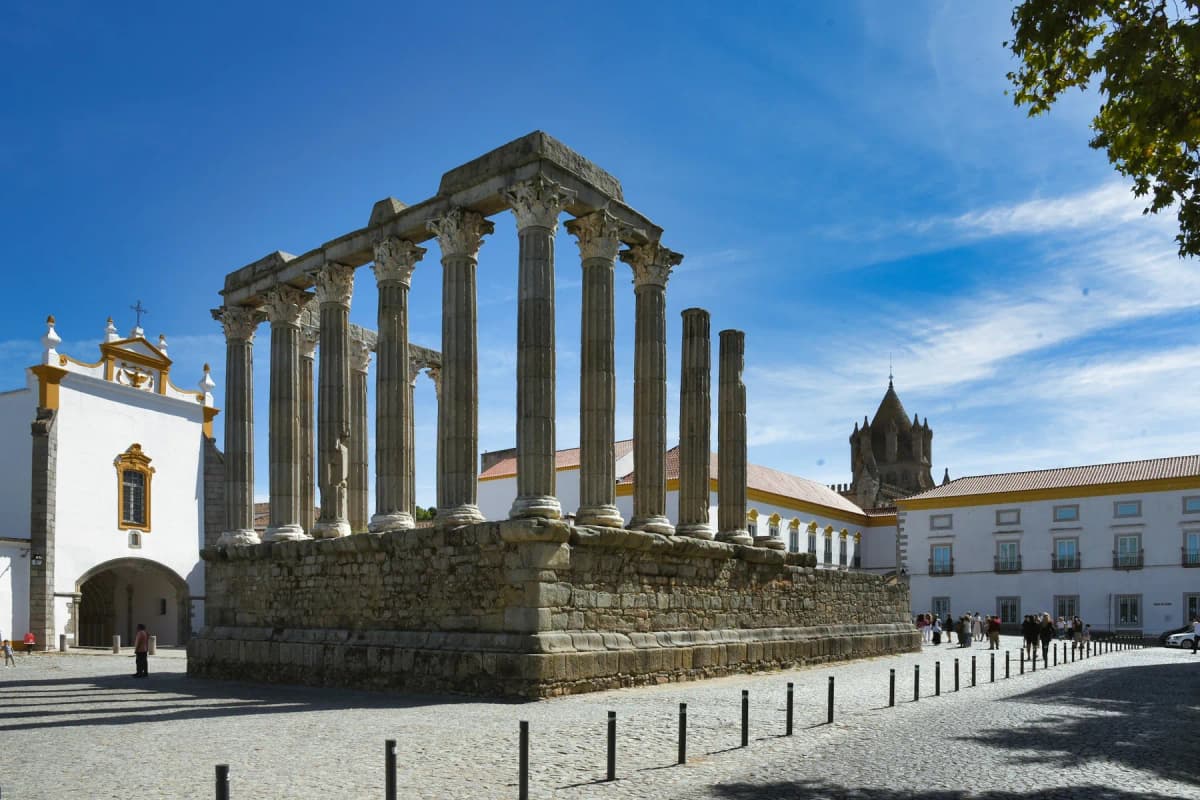 The Roman Temple of Évora with its Corinthian columns beside a white church