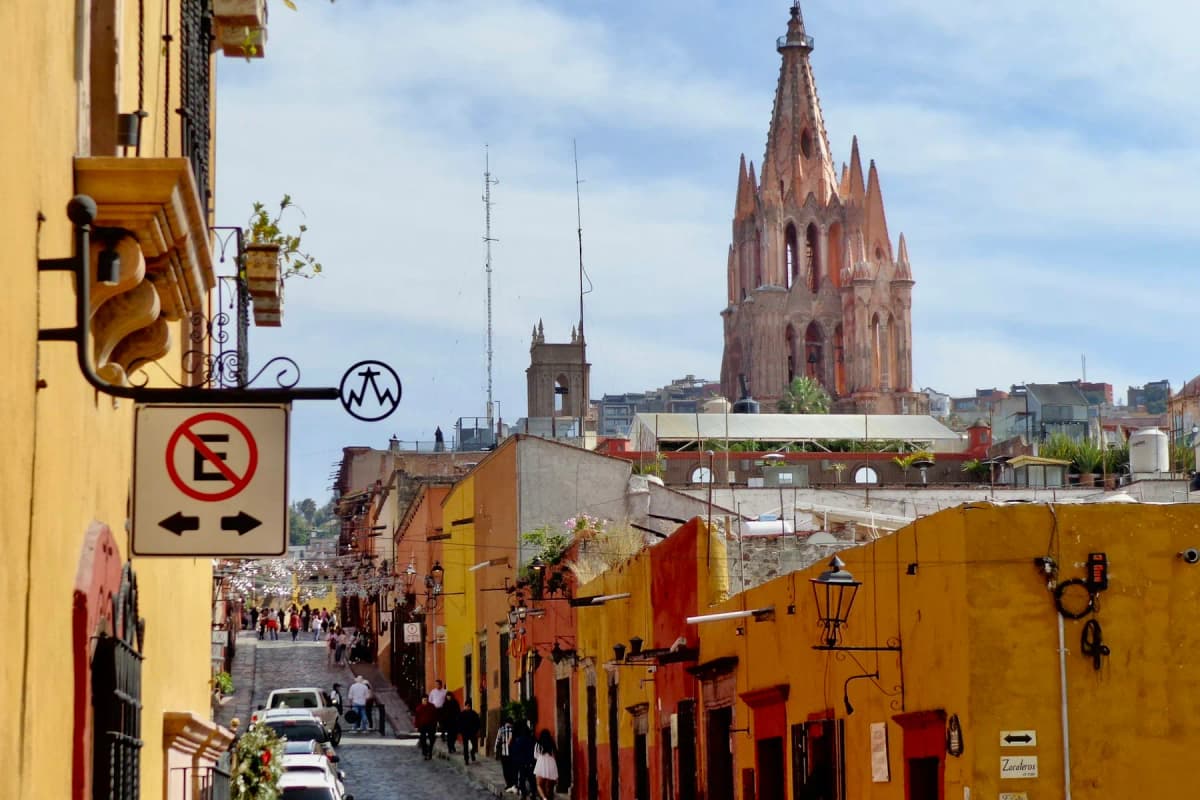 A cobbled street leading to the pink spire of the Parroquia in San Miguel de Allende