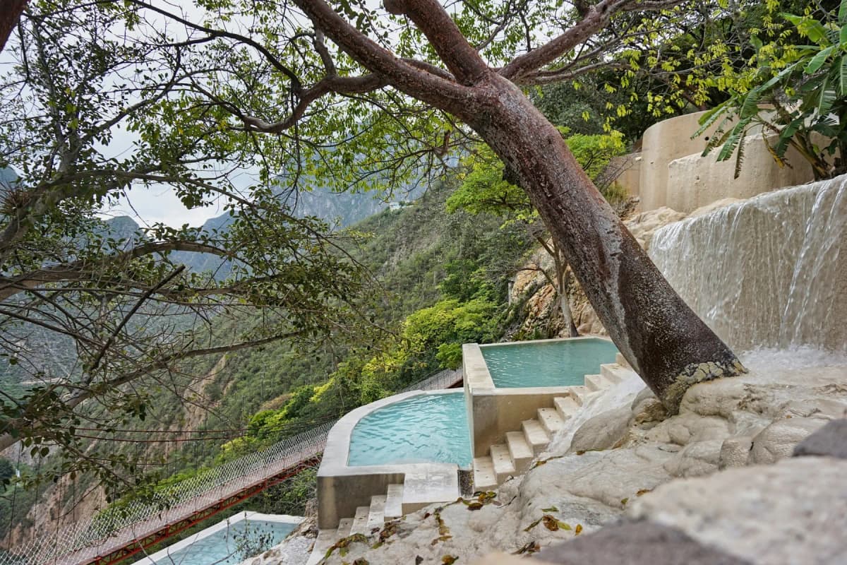 The turquoise hot spring pools on the canyon wall at Grutas Tolantongo