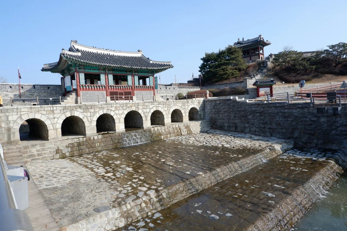 The Hwahongmun floodgate at Suwon's Hwaseong Fortress, with arches over the stream and a pavilion above