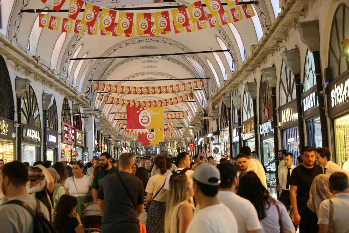 A busy covered street in the Grand Bazaar decorated with flags