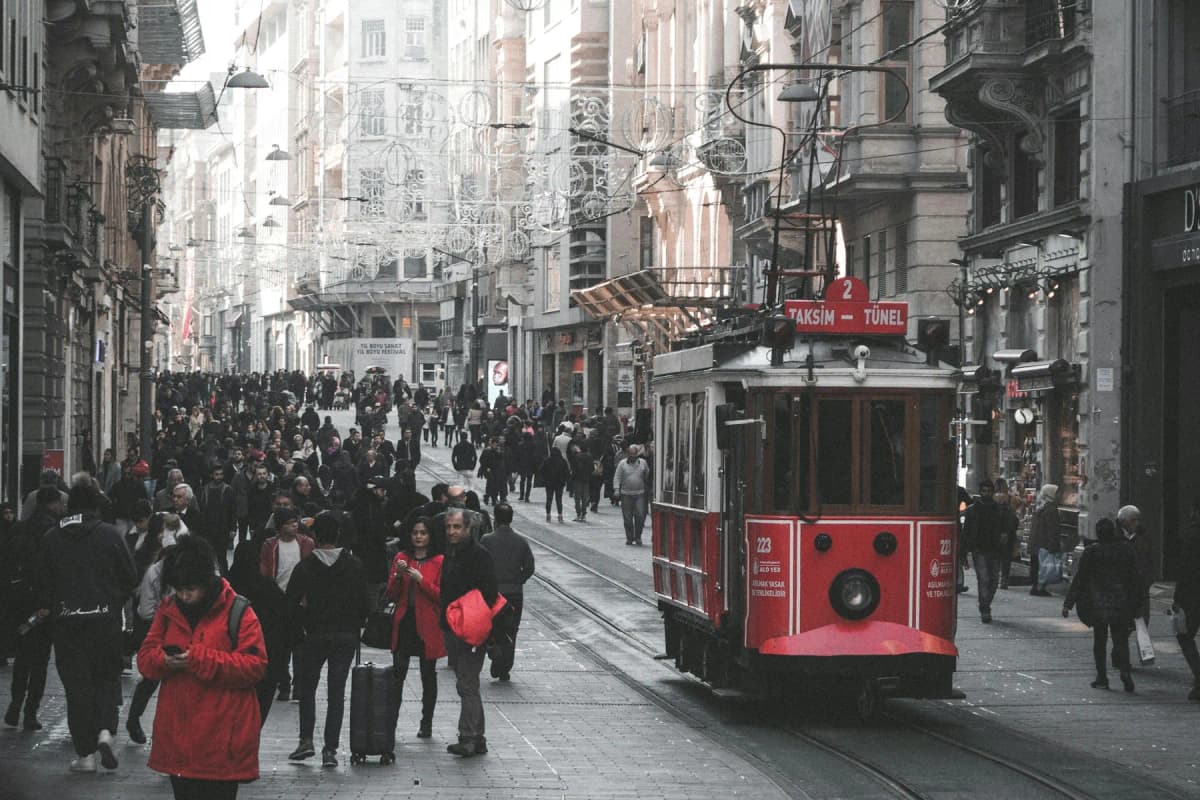 Crowds walking along İstiklal Avenue beside the red nostalgic tram