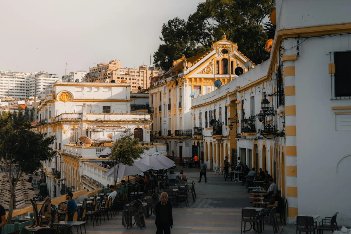 A café-lined street of white and yellow colonial buildings in the new town of Tangier