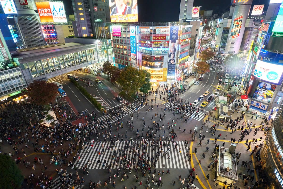 Crowds crossing the Shibuya scramble intersection in Tokyo at night