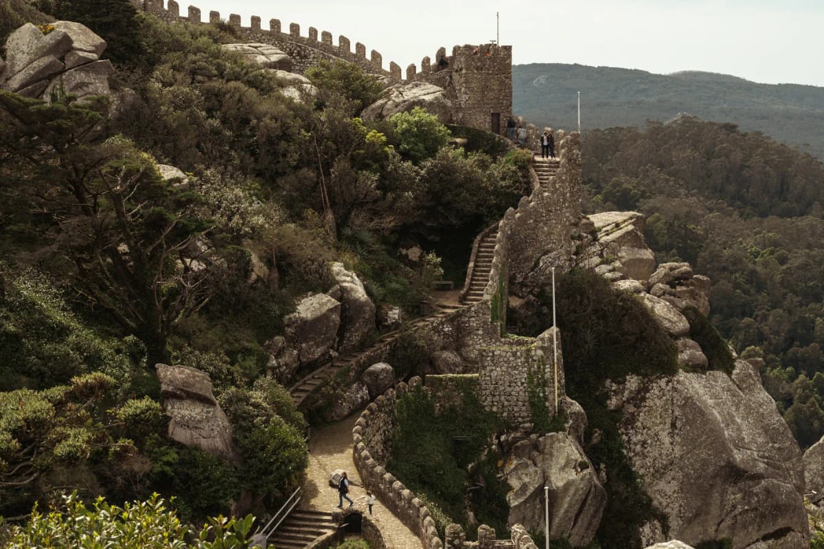 The stone walls of the Moorish Castle snaking along a forested ridge in Sintra