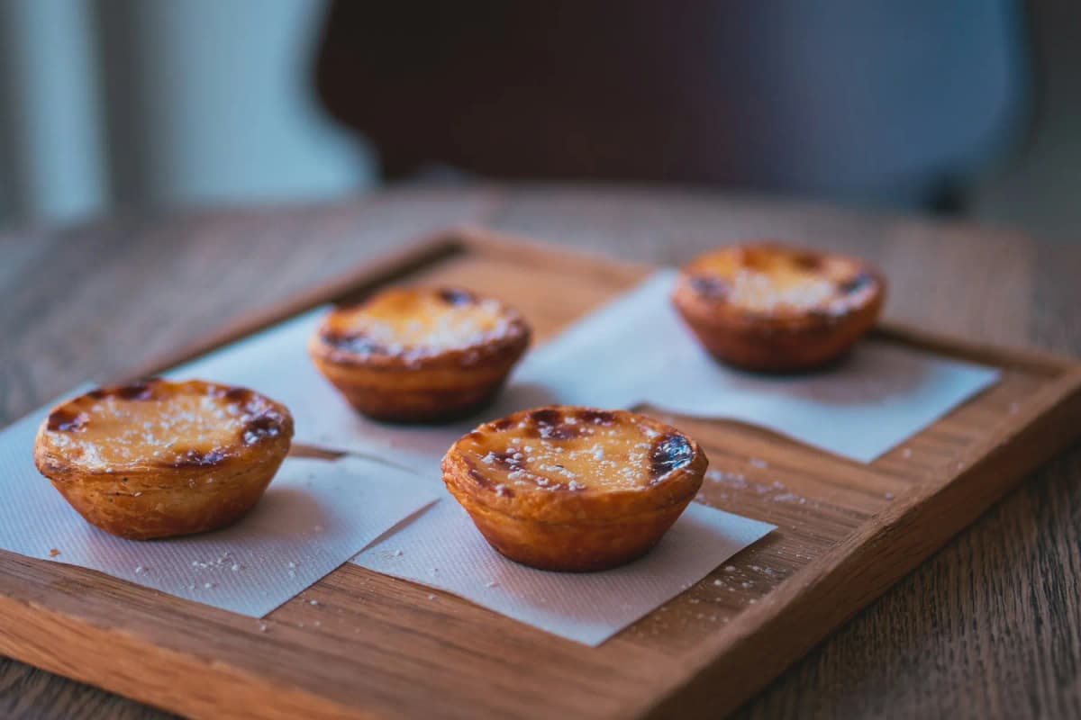 A box of Portuguese custard tarts, pastéis de nata, dusted with cinnamon