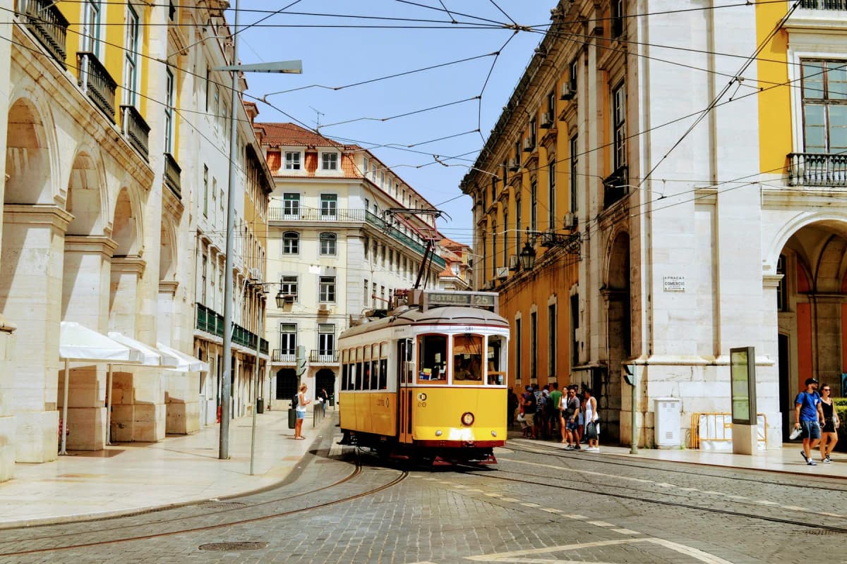 A yellow Lisbon tram running along a street in the Baixa