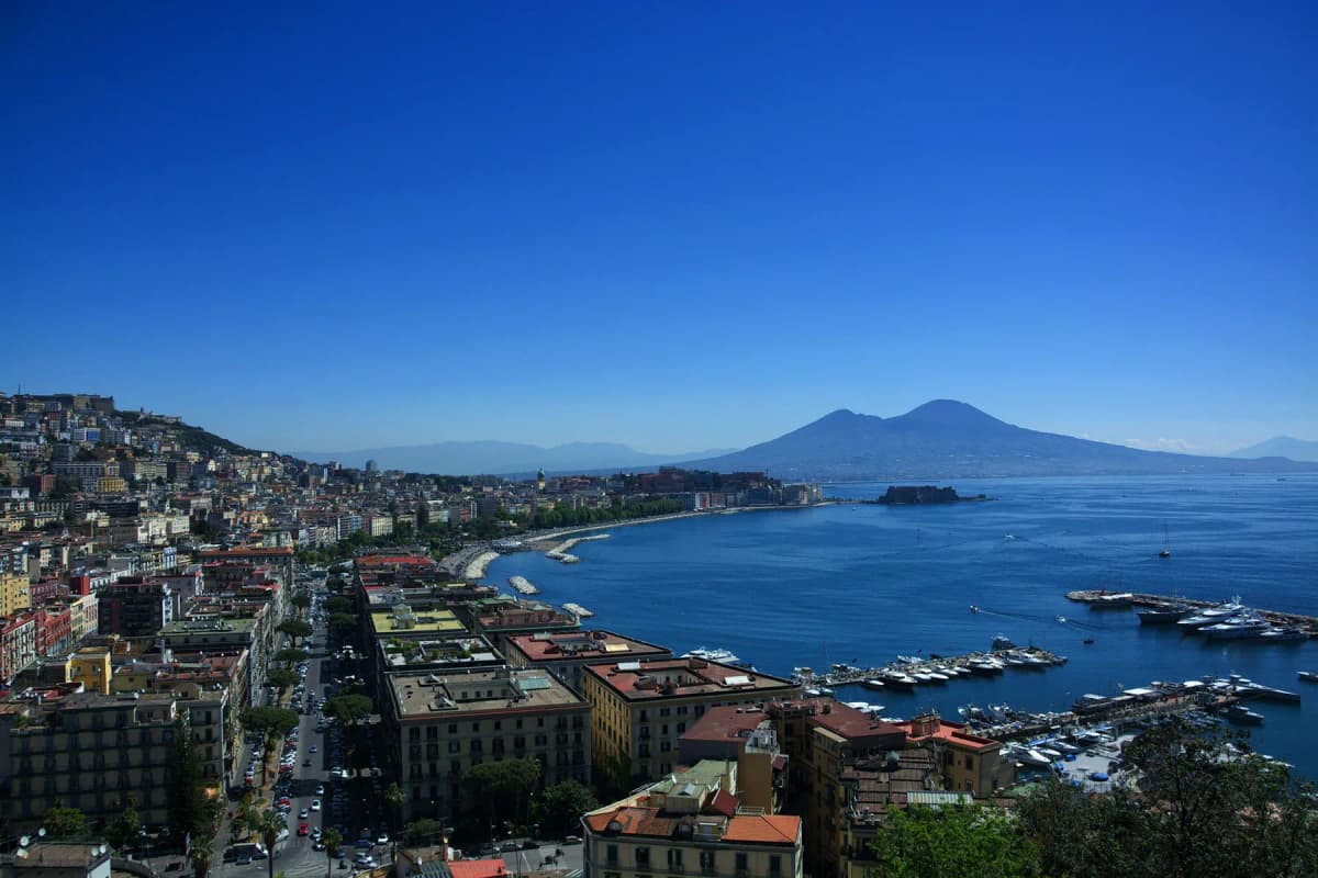 The city of Naples and its bay seen from above, with Mount Vesuvius in the background