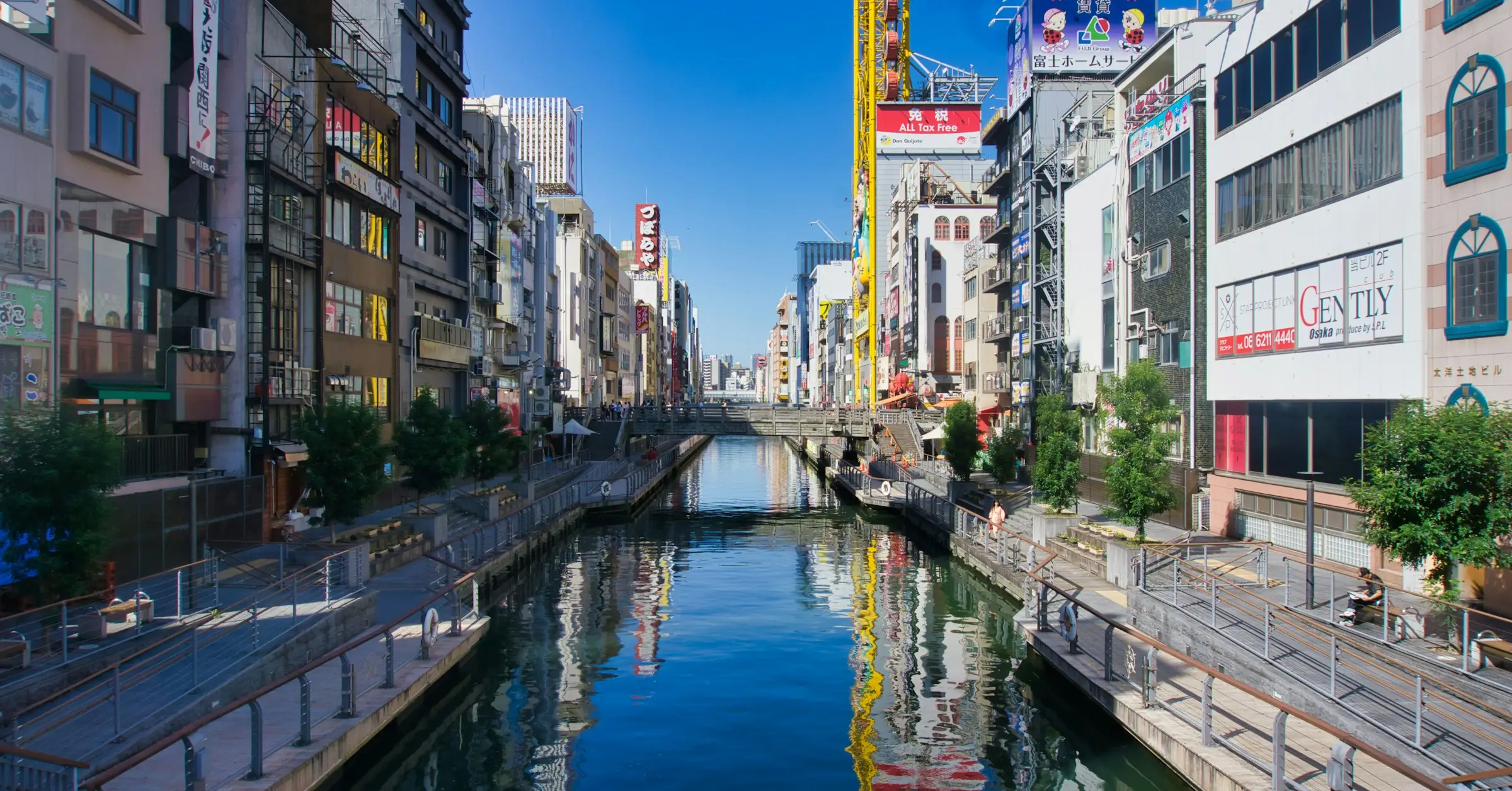 Osaka itinerary: the Dotonbori canal lined with buildings and signs on a clear day