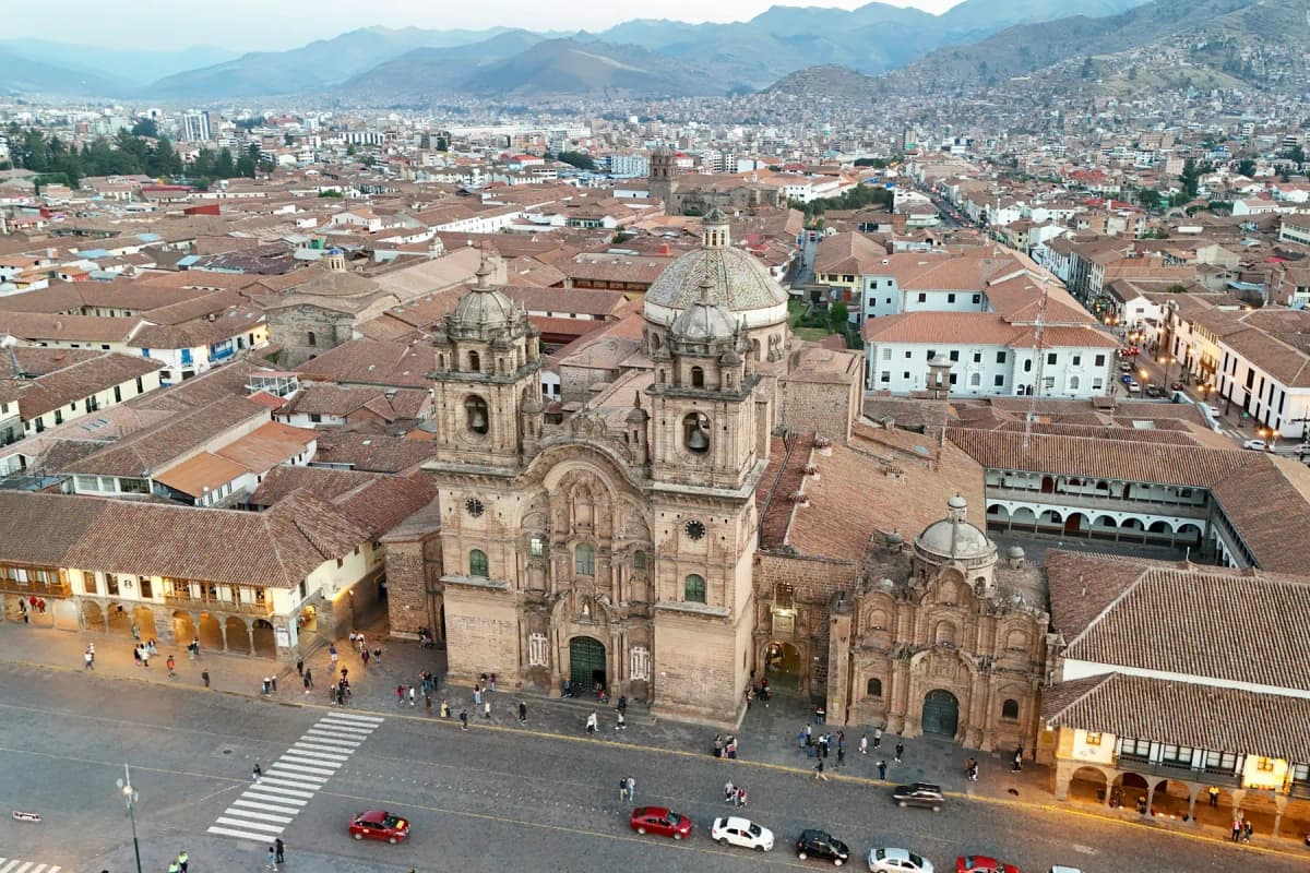 Aerial view of Cusco's Plaza de Armas and its churches, with the city spreading up the hills