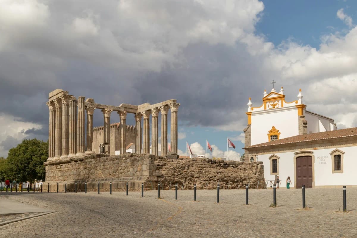 The Roman Temple of Évora in front of a white church in the Alentejo