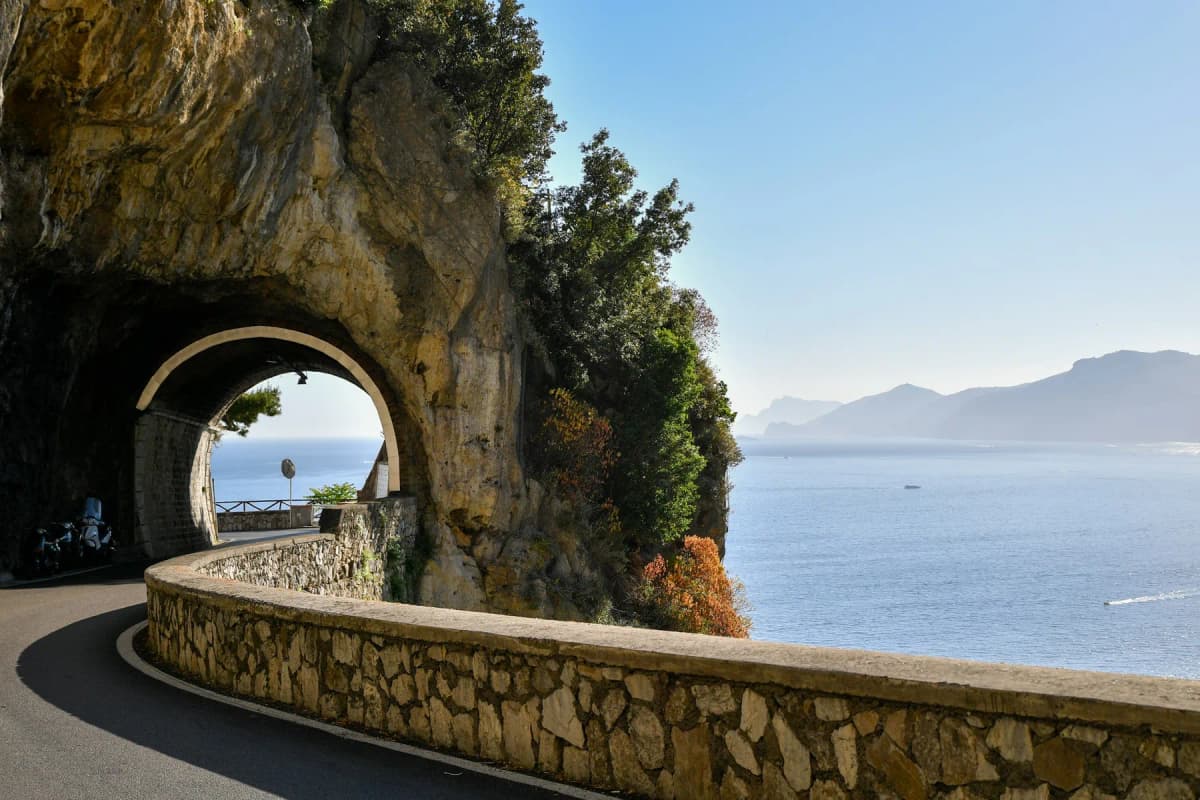 The Amalfi Coast road passing through a rock tunnel above the sea