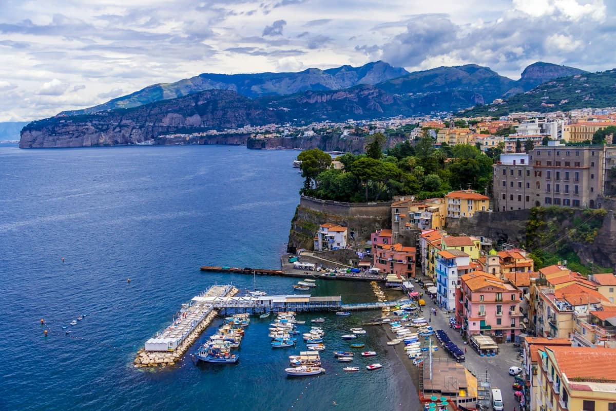 Aerial view of Sorrento's harbour with boats, the town on the cliff above and the coast beyond