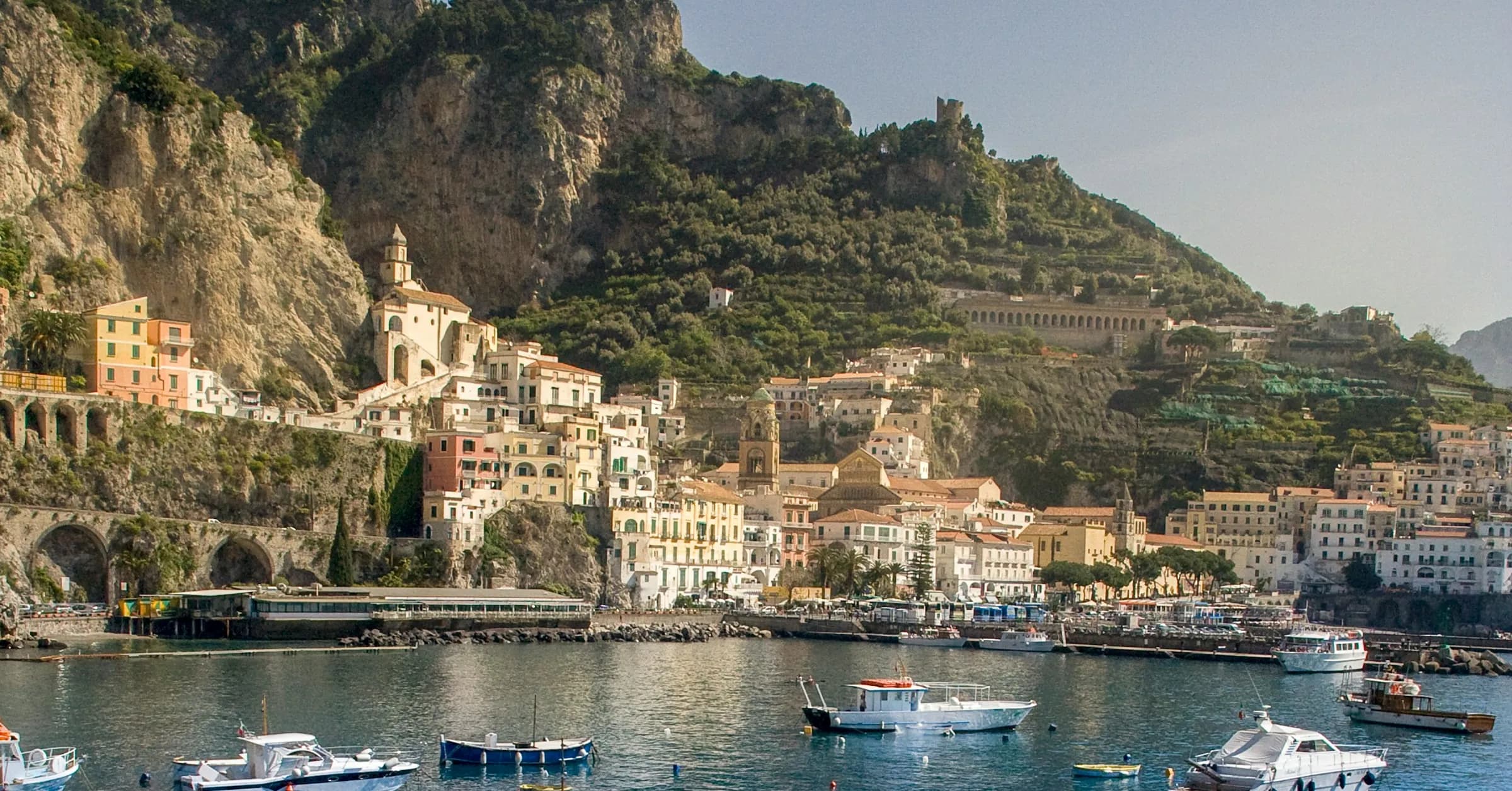 Rome to Amalfi Coast: fishing boats in the harbour at Amalfi with the town and mountains behind