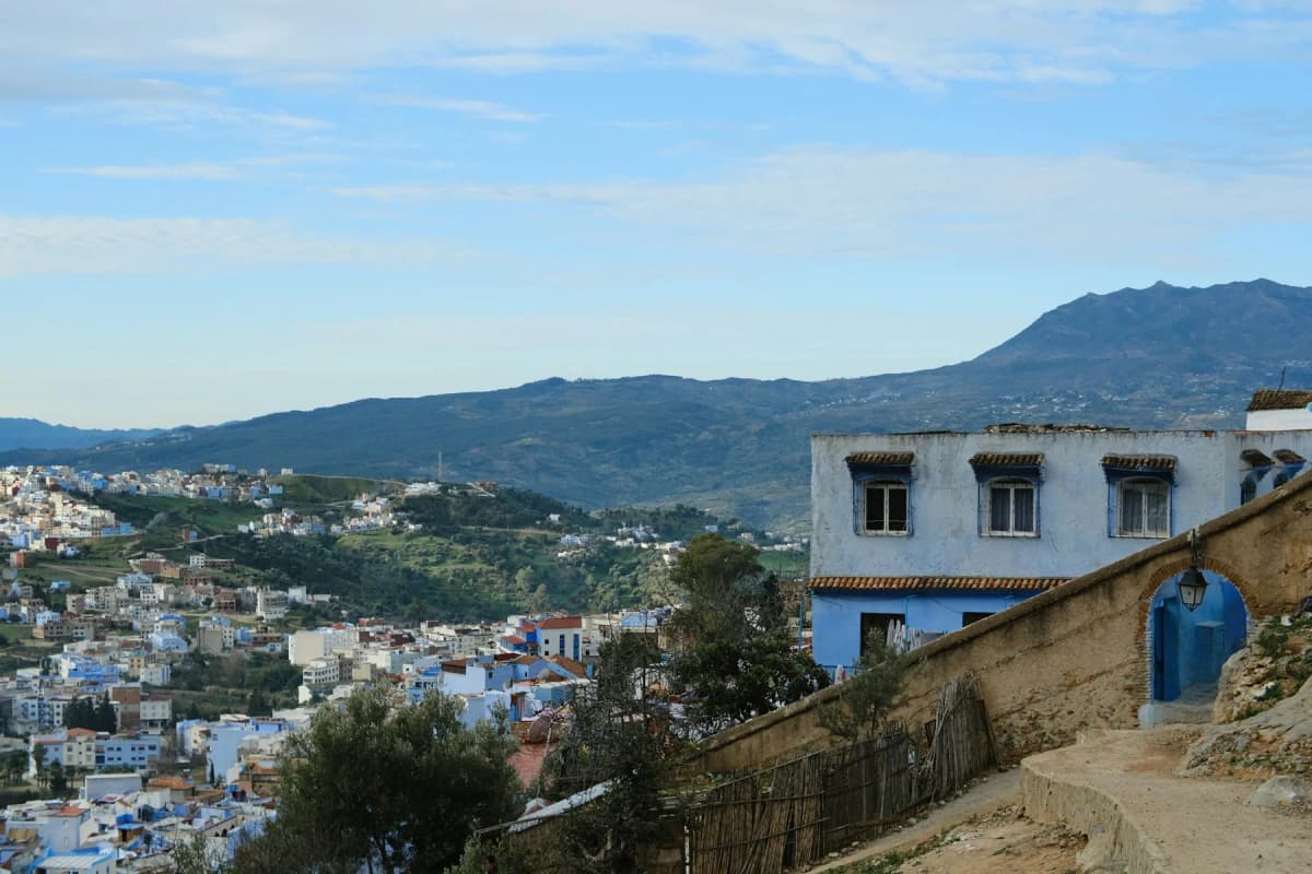 View over the blue and white houses of Chefchaouen and the Rif hills from a lane above the town