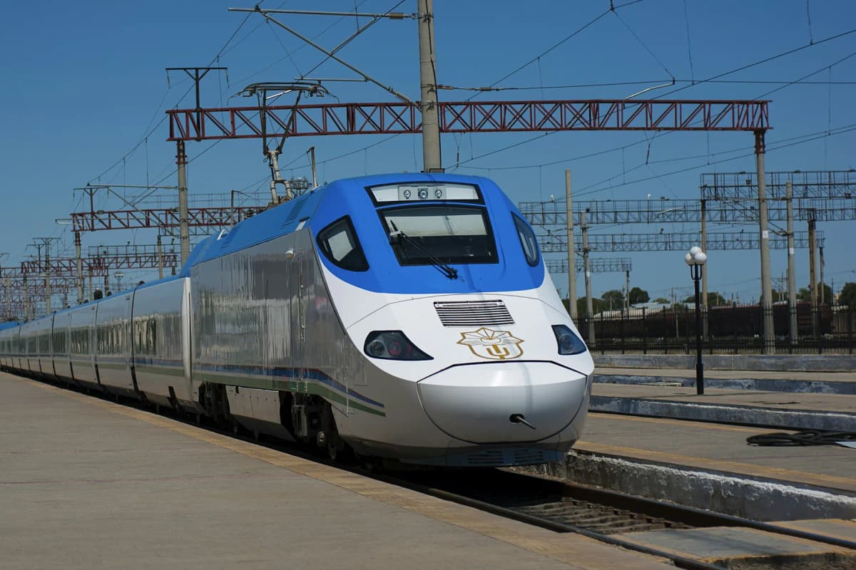 A white and blue Afrosiyob high-speed train at a station platform in Uzbekistan