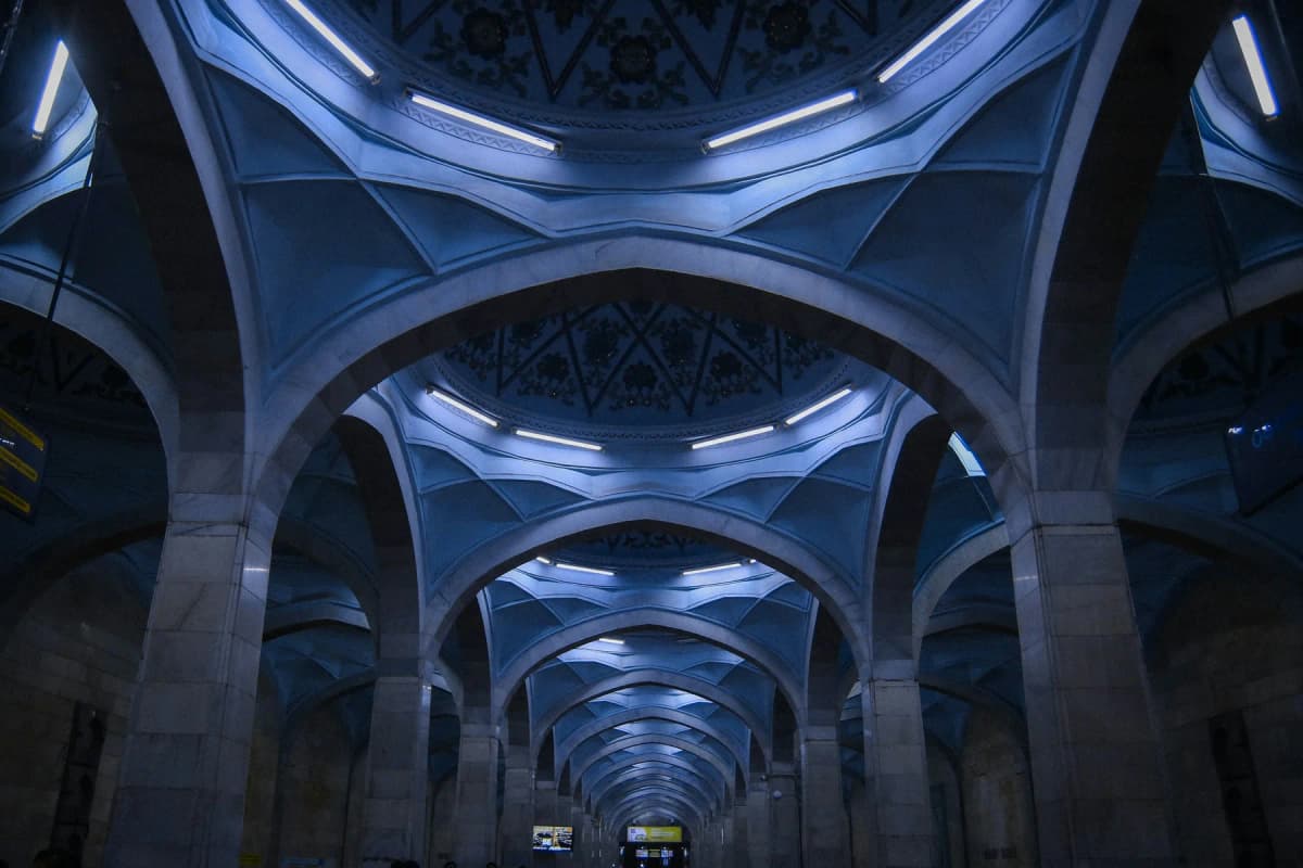 The domed hall of a Tashkent metro station, with lights set into carved arches