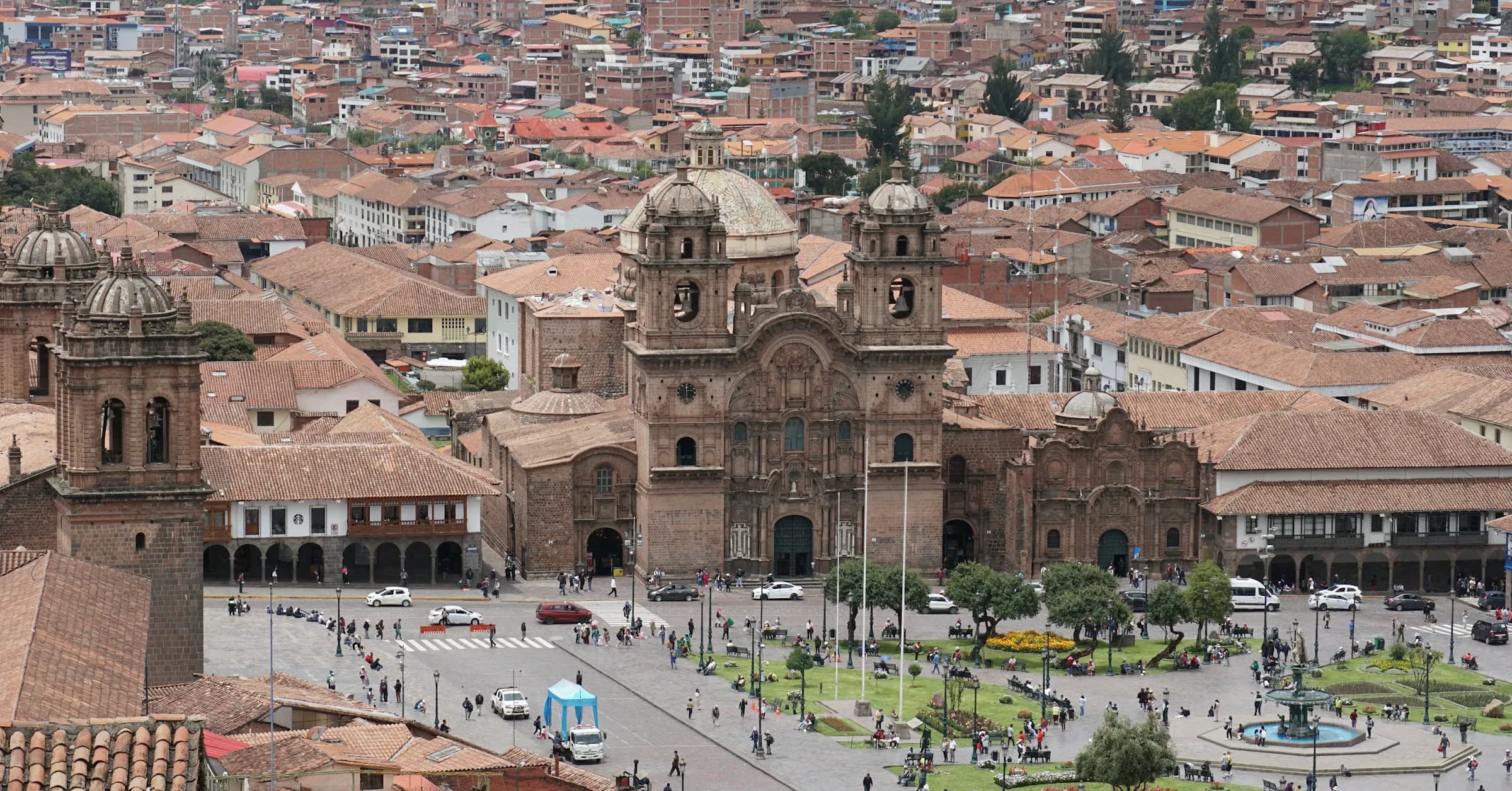 Things to do in Cusco: an aerial view of the Plaza de Armas and the cathedral, surrounded by red-tiled roofs