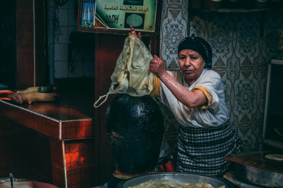 A woman preparing food at a small stall in the Fes medina