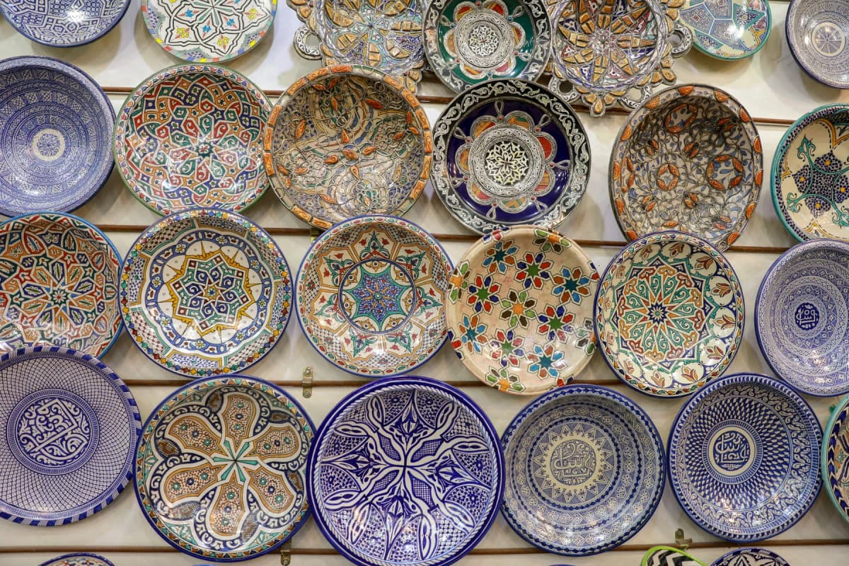 Hand-painted blue and multicoloured ceramic plates from Fes displayed on a wall