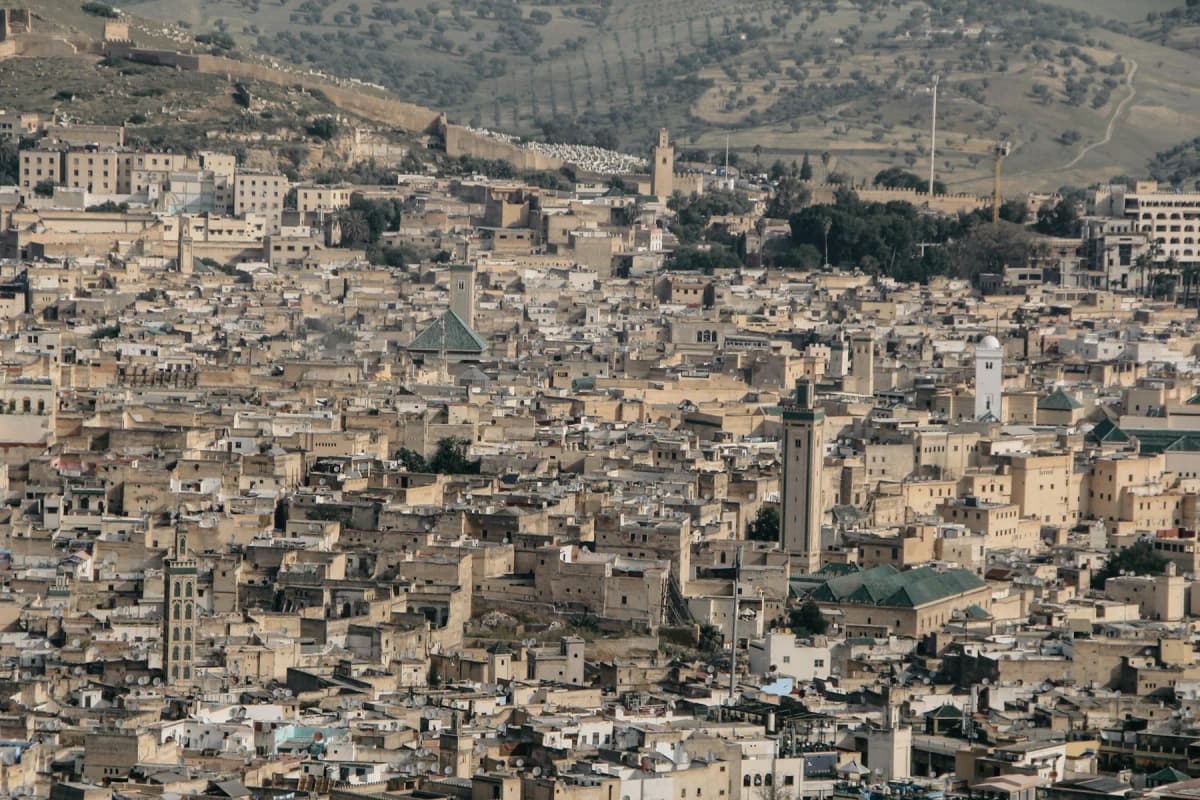 The dense rooftops and minarets of the Fes medina seen from the hills above the city