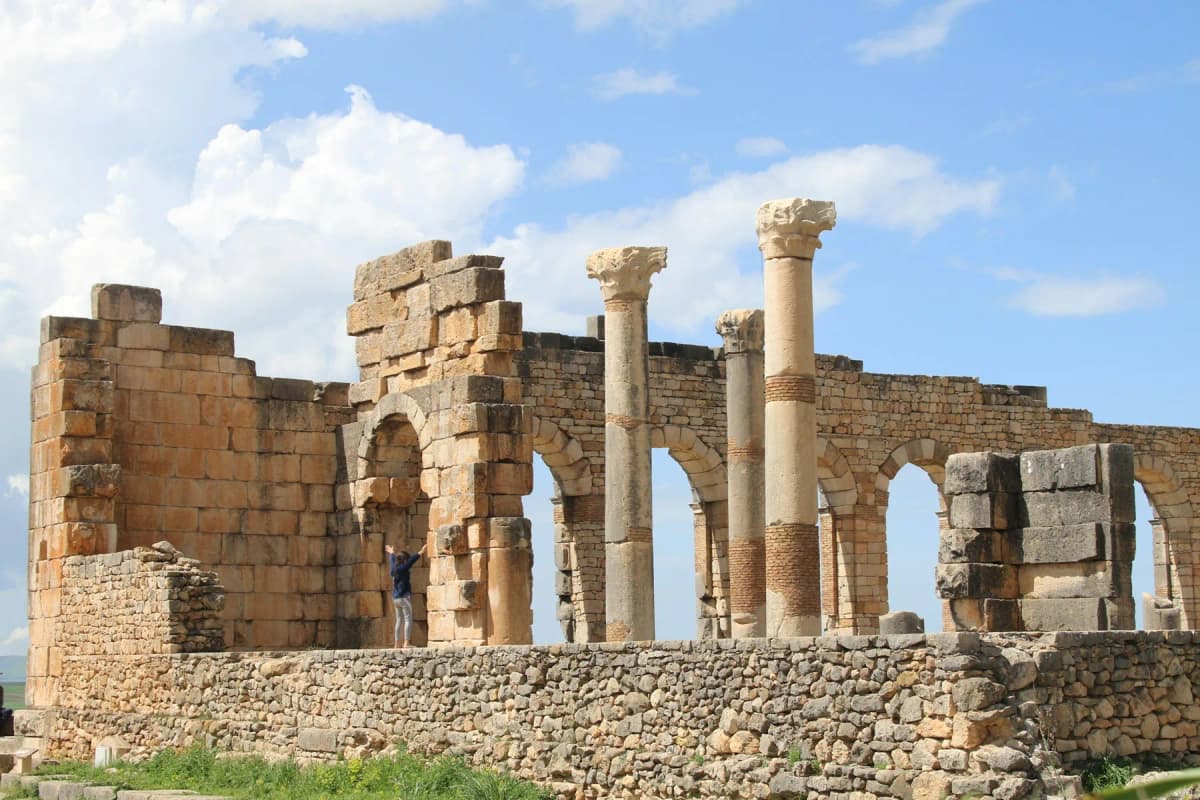 Roman columns and arches standing among the ruins of Volubilis near Fes