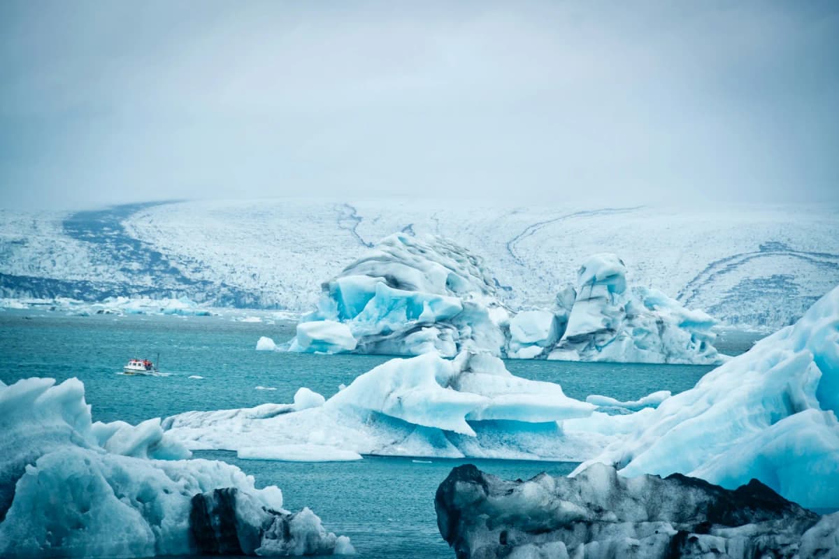 Blue and white icebergs floating in Jökulsárlón glacier lagoon with the glacier behind