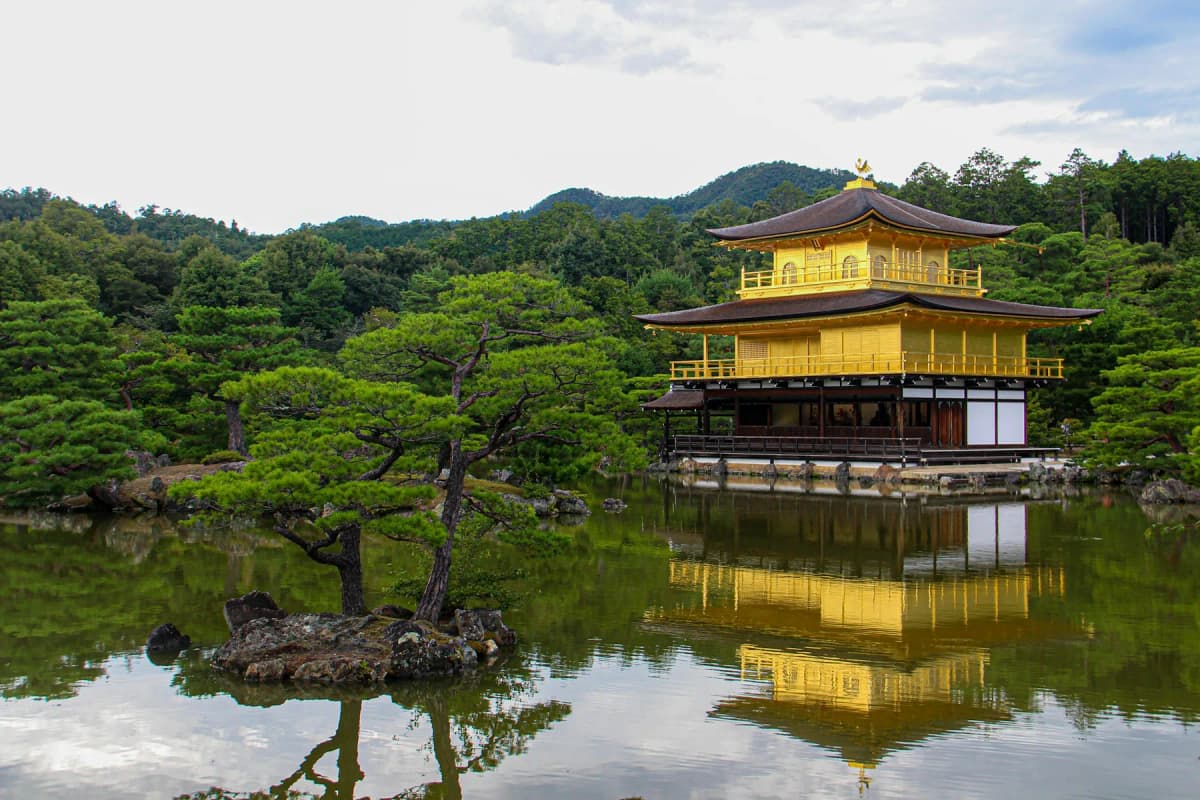 Kinkaku-ji, the Golden Pavilion, reflected in its pond with pine trees in Kyoto