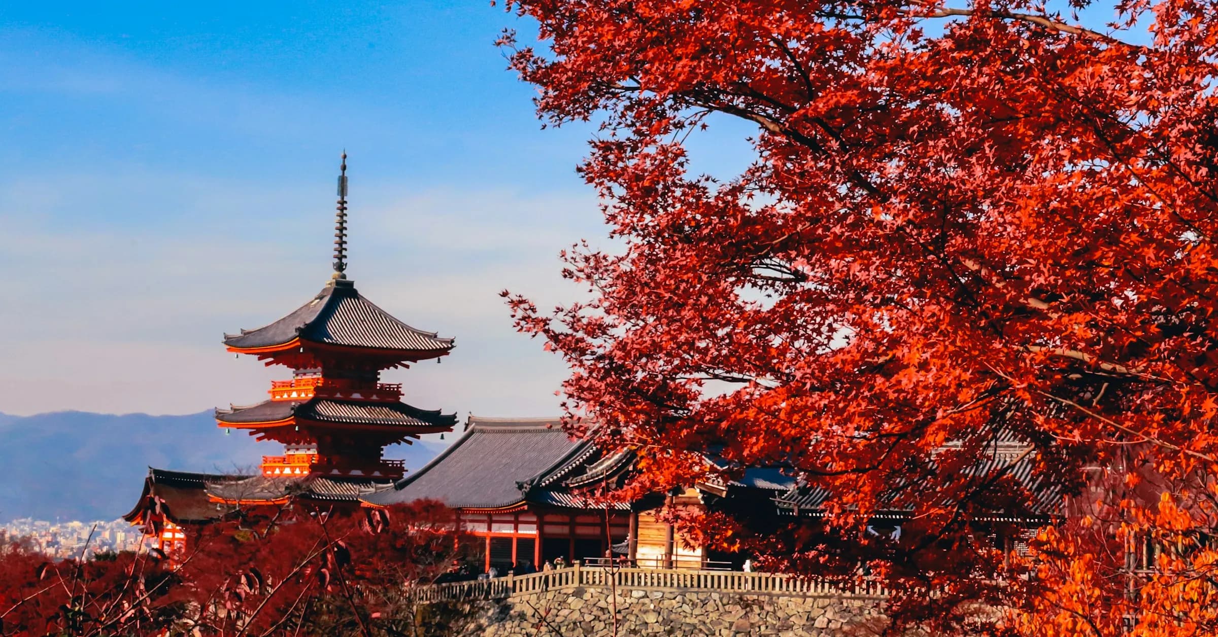 Things to do in Kyoto: the pagoda of Kiyomizu-dera temple framed by red autumn maple leaves