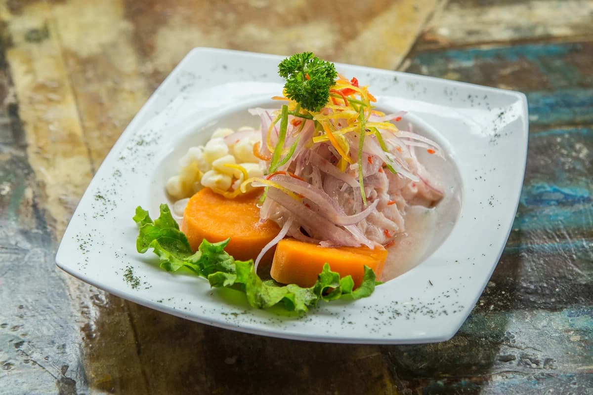 A plate of Peruvian ceviche with sweet potato and corn, served in Lima