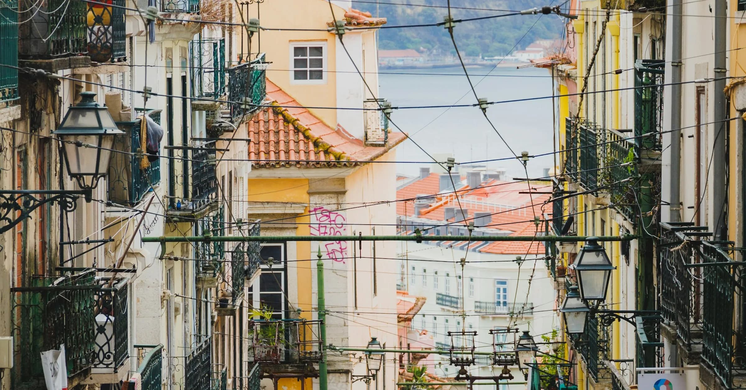 Things to do in Lisbon: the yellow trams of Elevador da Bica climbing a steep street in the old town