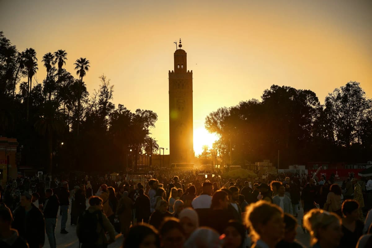 Things to do in Marrakech: crowds in Jemaa el-Fnaa square at sunset with the Koutoubia minaret behind