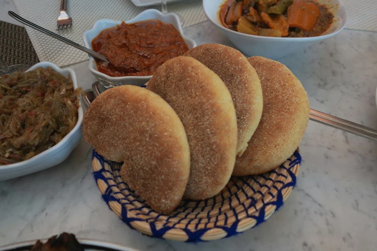 A spread of Moroccan bread, olives and small salads on a table