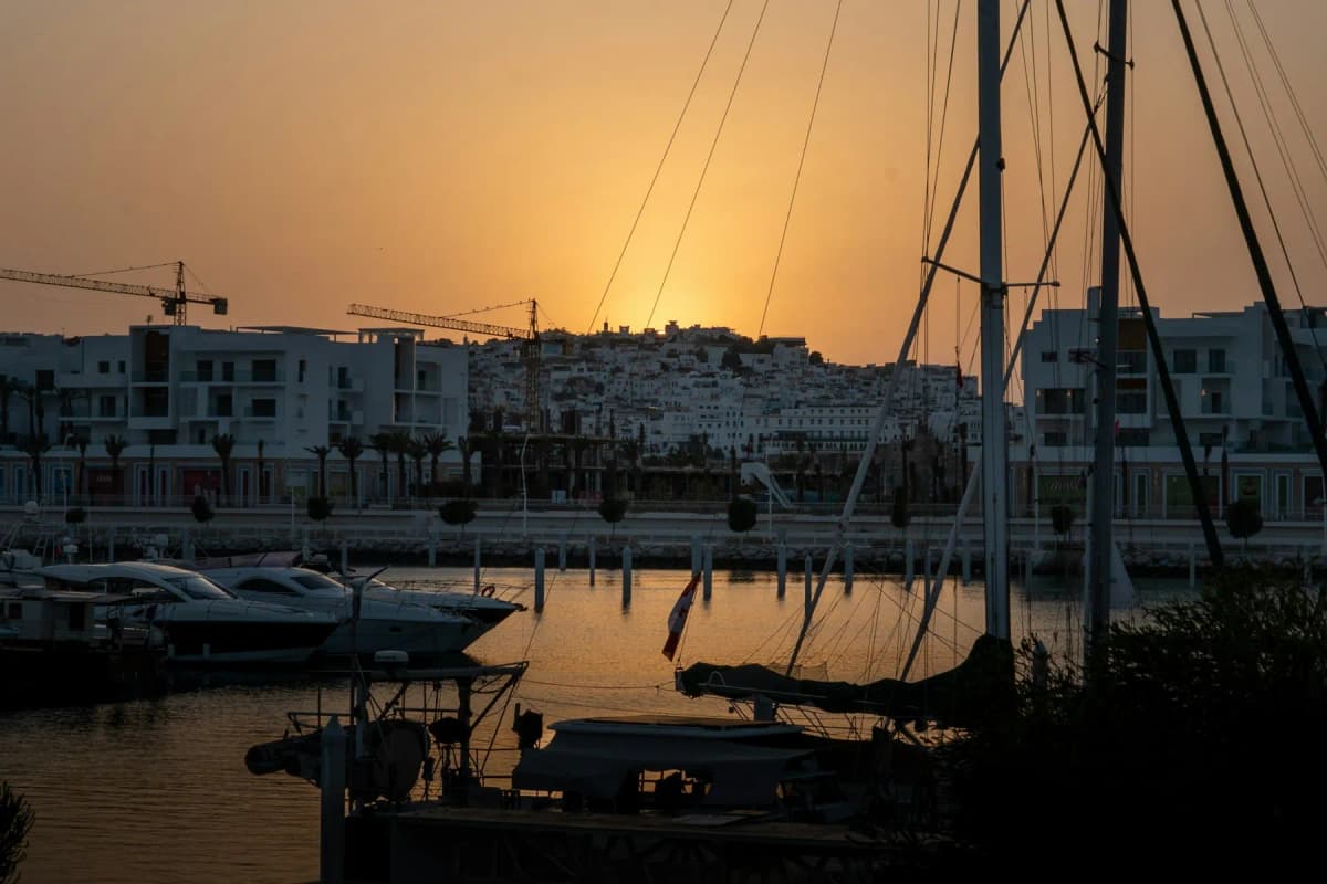 Sunset over the yachts of Tanja Marina Bay with the white houses of Tangier's medina behind