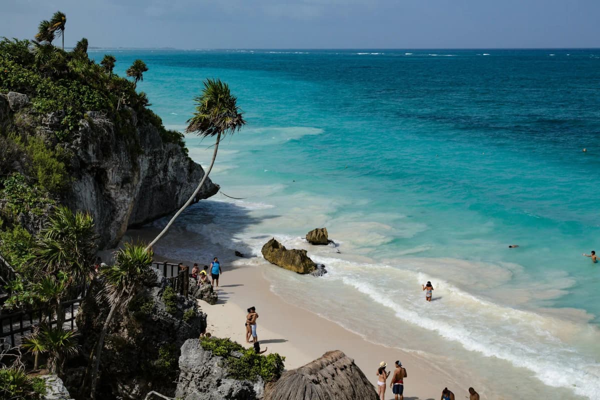 The beach below the Tulum ruins, with swimmers in the turquoise water