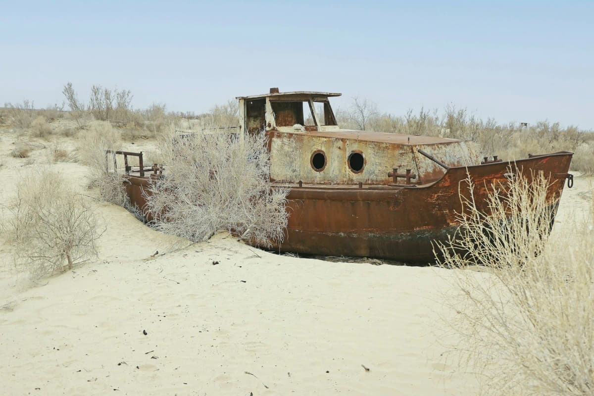A rusting boat stranded on the sand of the former Aral Sea seabed at Moynaq